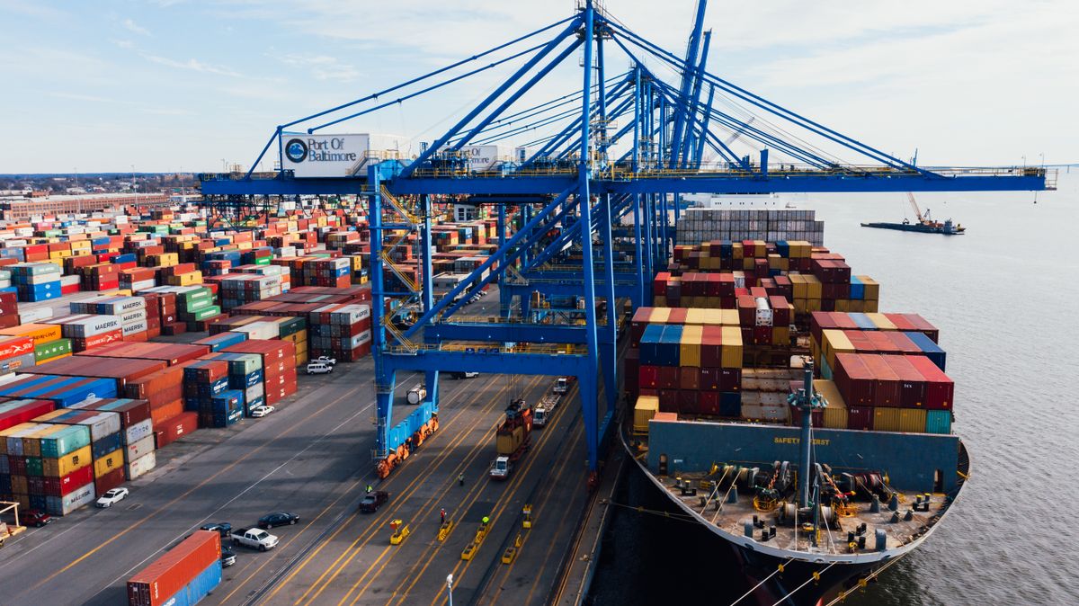 Cargo ship unloading colorful shipping containers at a port, illustrating trade that feeds into GDP