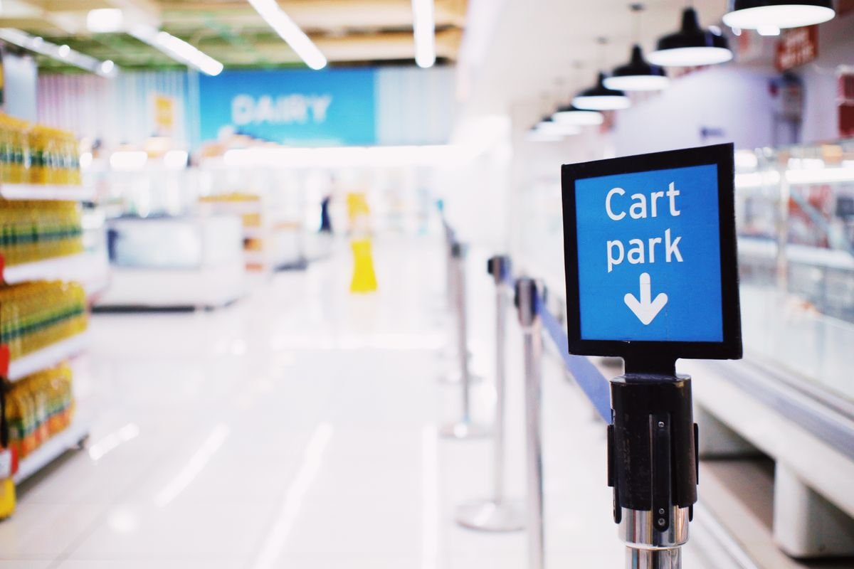Rows of shopping carts inside a bright modern supermarket entrance
