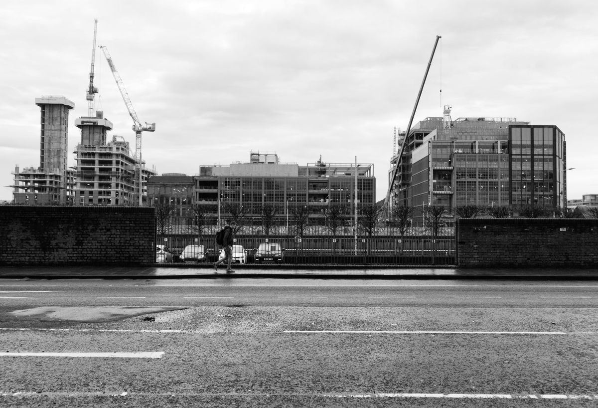 Multiple tower cranes working across a developing city skyline